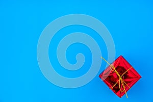 red gift box with yellow ribbon on blue background