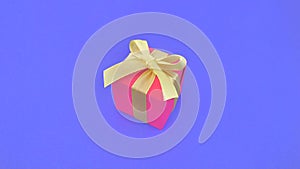 Red gift box with yellow ribbon on indigo background.