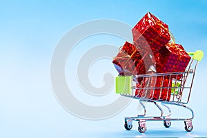 Red gift boxes in a basket on a blue background. Buying gifts for Christmas
