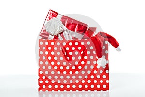 Red gift boxes and and christmas hat in shopping bags