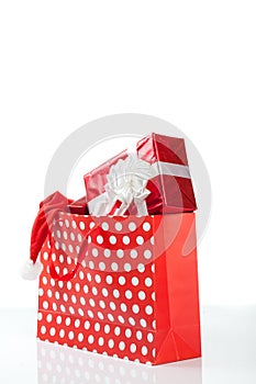 Red gift boxes and and christmas hat in shopping bags