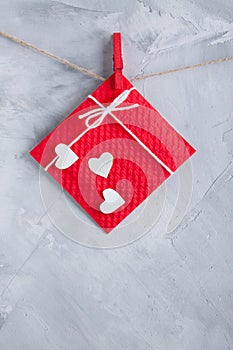 Red gift card wih paper hearts on gray concrete background.