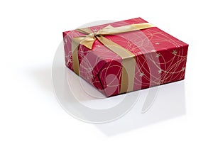 Red gift with gold satin ribbon bow on white background