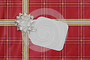 Red gift wrapped package with large blank tag