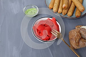 Red ginger in a plate with bread meat on a gray background with space for text. Sandwich recipe. Application of sauces