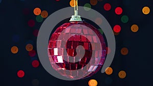 Red glass Christmas ornament swing with blinking lights behind