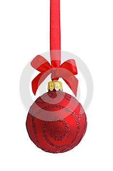 Red glass glitter Christmas bauble hanging on a red satin ribbon with a bow, isolated