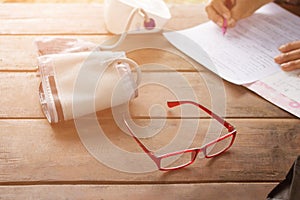 Red glasses with Blood Pressure Monitors with Blood Pressure Monitors, Woman holding pens to write inspection reports