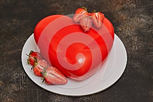 Red glaze mousse cake, heart shape form on dark background