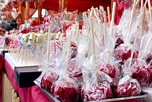 Red glazed candy apples wrapped in cellophane on display