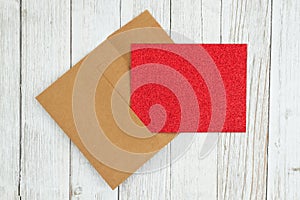 Red glitter blank greeting card and envelope on weathered whitewash textured wood background