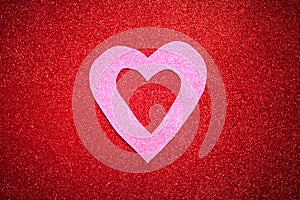 Red glittery background with pink heart, Valentine`s Day, texture abstract background, suitable for ads, insert text, romantic