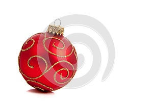 A red, glittery Christmas ornament on white photo