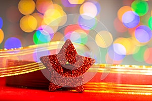 Red glittery decoration in a colorful Christmas composition isolated on background of blurred lights