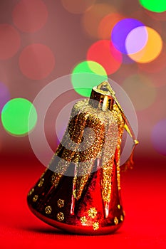 Red glittery decoration in a colorful Christmas composition isolated on background of blurred lights