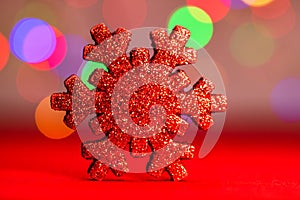 Red glittery decoration in a colorful Christmas composition isolated on background of blurred lights