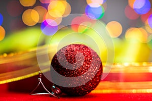 Red glittery decoration in a colorful Christmas composition isolated on background of blurred lights