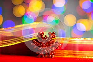 Red glittery decoration in a colorful Christmas composition isolated on background of blurred lights