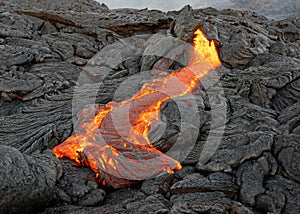 Red glowing lava flow on Hawaii photo