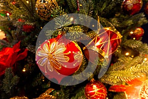 Red and gold bauble ornament in green decorated Christmas tree