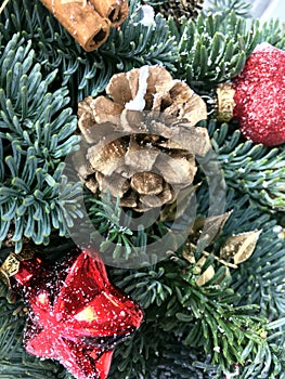Red and gold Christmas ball, gold pine cone, cinnamon, gold leaves and toys on Christmas tree. Christmas background