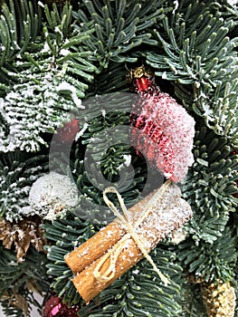 Red and gold Christmas ball, gold pine cone, cinnamon, gold leaves and toys on Christmas tree. Christmas background