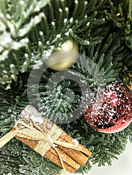 Red and gold Christmas ball, gold pine cone, cinnamon, gold leaves and toys on Christmas tree. Christmas background
