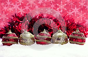 Red and gold Christmas balls in snow with tinsel and snowflakes, christmas background