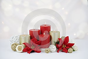 Red and gold burning Christmas candles background with poinsettia flowers