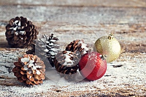 Red and gold christmas ornament pine cones on wooden