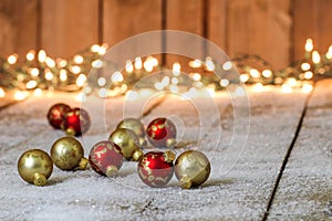 Red and gold Christmas ornaments on snowy background