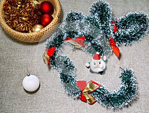 Red gold ribbons Christmas garland, baubles and Santa Claus toy.