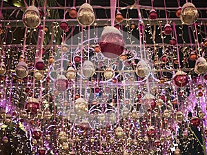 Red and golden new year spheres with illumination. New year street decoration in the evening