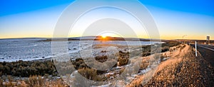 Red Golden Winter Sunset Setting on the Horizon of Vast Hilly Farmland By Highway Under Darken Blue Sky, Washington, United States