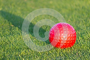 Red golf ball on grass