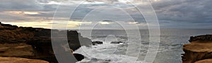 Red granite Cliffs at Sunset, Waves Breaking Shore, Ocean and Land Panorama