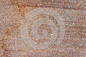 Red granite slab with stains close-up. Natural stone texture