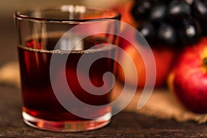 Red grape juice in glass, grapes and red apples