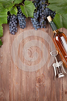 Red grape, wine bottle and corkscrew