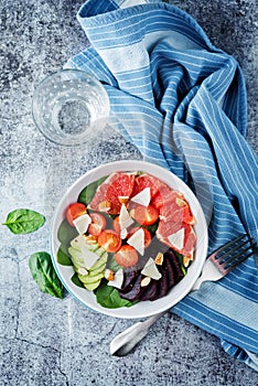 Red grapefruit beet spinach tomato salad in a bowl