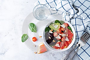 Red grapefruit beet spinach tomato salad in a bowl