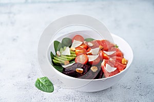 Red grapefruit beet spinach tomato salad in a bowl