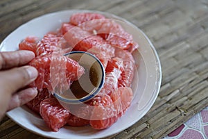 Red grapefruit dipped in sauce very dilicious somewhere in Thailand photo