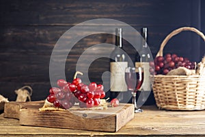 Red grapes with a bunch of grapes in a sweet natural fruit wooden basket with a wine bottle Placed on the table, black and dark