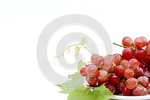 Red grapes with fresh leaves, isolated on white ba