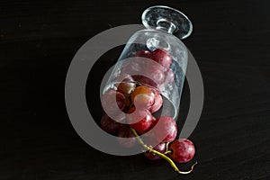 Red grapes, large bunch of fruits, fresh and tasty simple food on a dark background in a fancy minimal composition