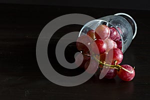 Red grapes, large bunch of fruits, fresh and tasty simple food on a dark background in a fancy minimal composition