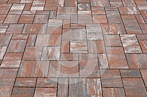 Red and gray concrete tiled outdoor pavement with tiles of different shapes