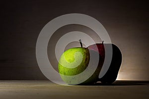 Red and green apple on wood