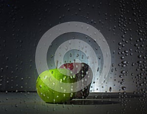 Red and green apple on wood,water beads on the glass